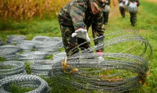 Hungarian soldiers with barbed-wire fencing on the border with Slovenia in September 2015. Photo by Jure Makovec