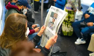 A New York train passenger reads a newspaper reporting on big tech company executives testifying to a congressional committee investigating monopoly policies. Image credit: Robert Nickelsberg via Getty Images