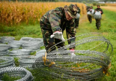 Hungarian soldiers with barbed-wire fencing on the border with Slovenia in September 2015. Photo by Jure Makovec