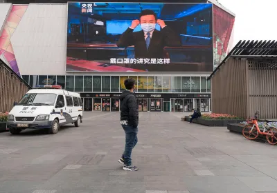 Chengdu, Sichuan / China - January 30, 2019: a screen at shopping district showing the broadcaster wearing a mask to host a news show regarding coronavirus.