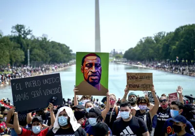 Demonstrators gather on the National Mall to protest racial injustice. An image of George Floyd is held up in front of the Washington Monument.