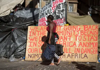 Woman walking in front of a protest "we are not going back"