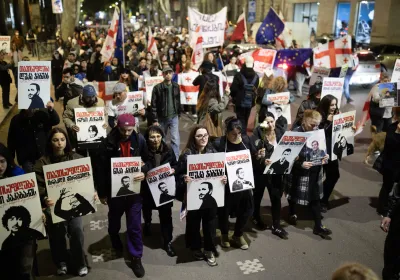 Demonstrators march in April 2025 with posters supporting Georgian prisoners of conscience
