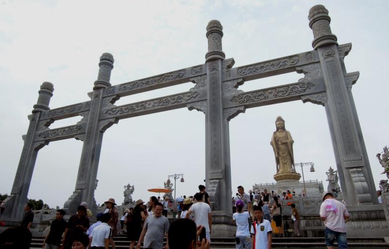 Visitors walk past the statue of a bodhisattva in a scenic park in Zhejiang Province. Credit: Kuei-min Chang