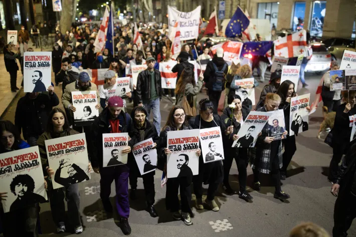 Demonstrators march in April 2025 with posters supporting Georgian prisoners of conscience